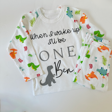 Load image into Gallery viewer, Children&#39;s pyjamas, white long sleeved with dinosaur printed arms. Pyjama bottoms with dinosaur print
